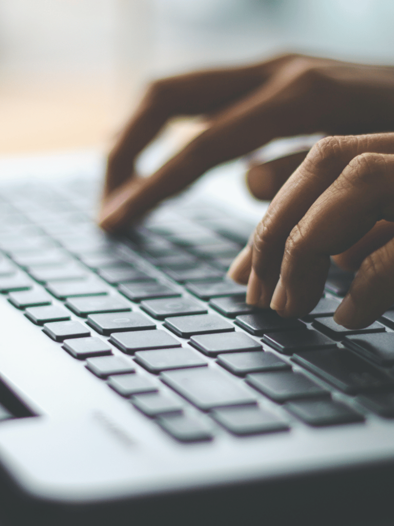 Close up of hands typing on a laptop